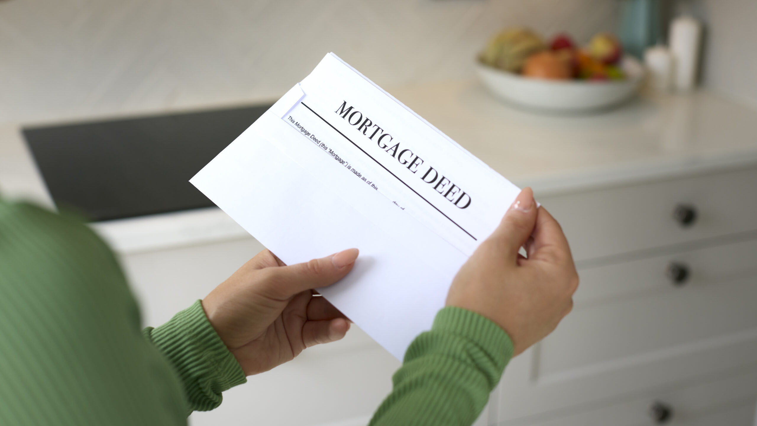 Close Up Of Woman Opening Letter Containing House Mortgage Deed