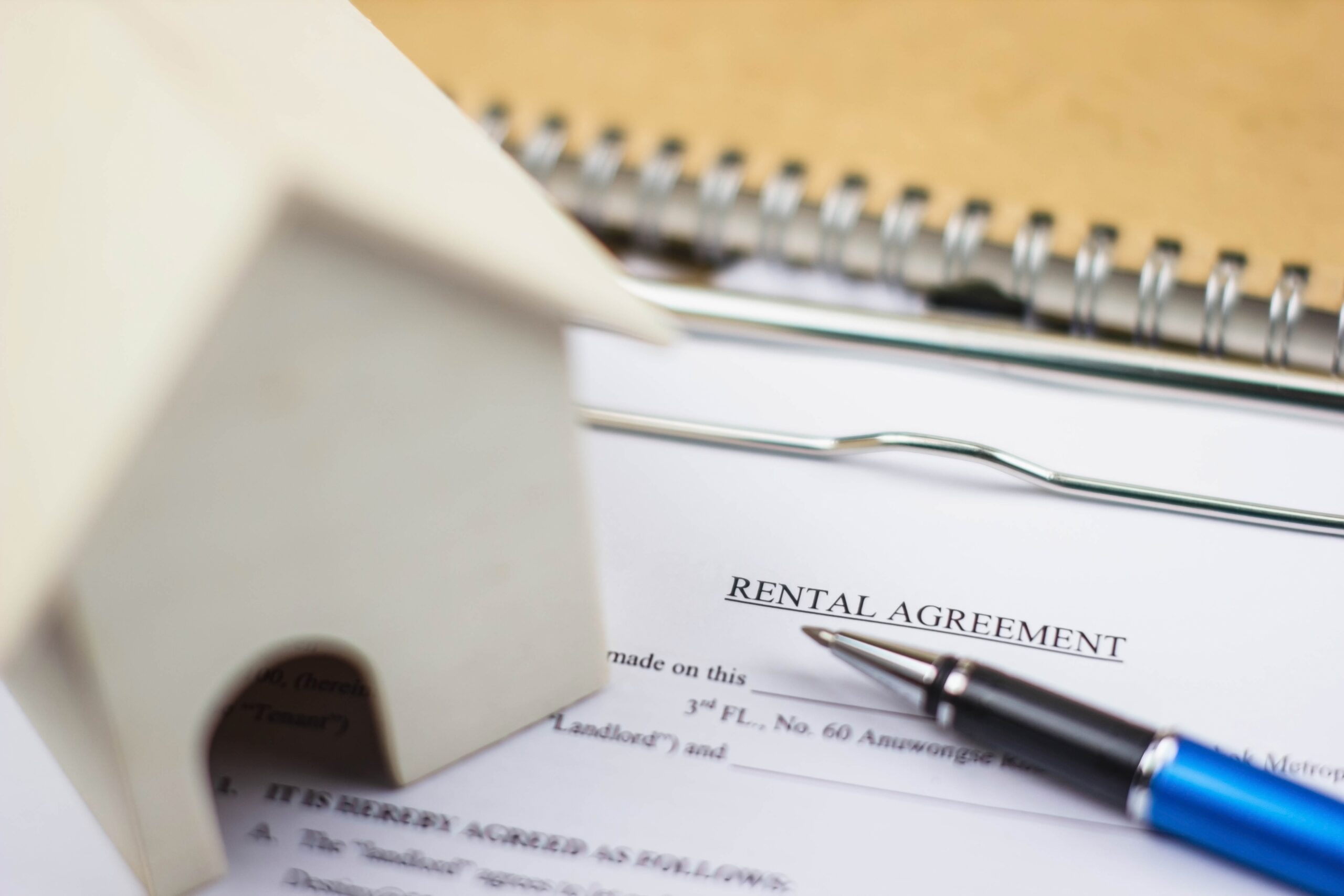 Home model and rental agreement document with pen