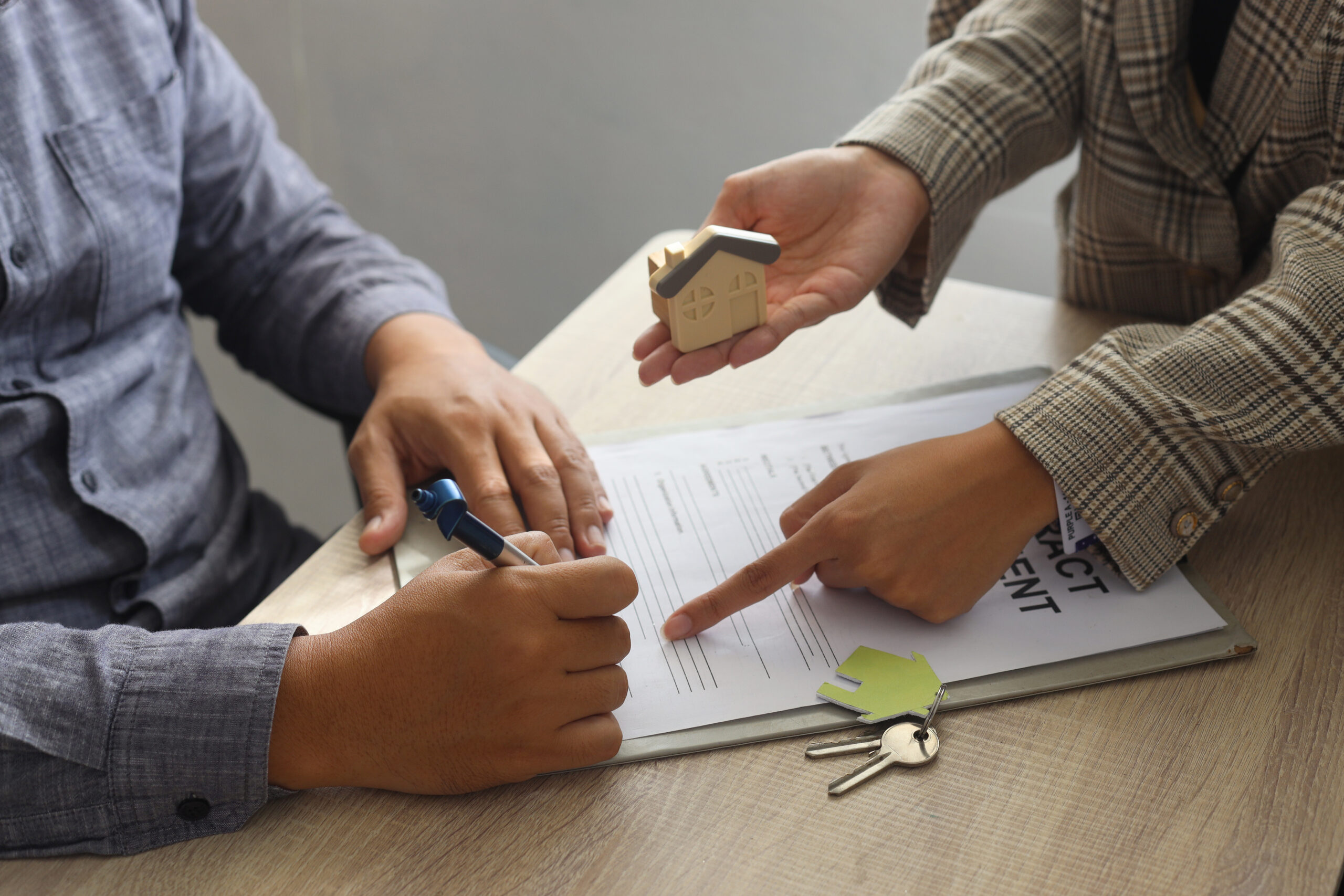 Real estate agent and customer signing sales contract